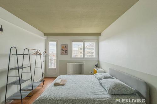 ein Schlafzimmer mit einem Bett mit einer Leiter und zwei Fenstern in der Unterkunft Flexliving - room - Losserand in Paris