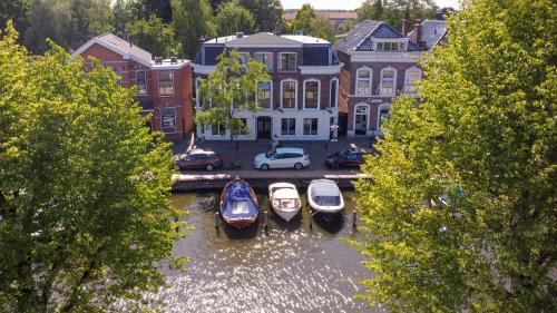 three boats are docked in the water in a city at Stadslogement Westersingel in Sneek