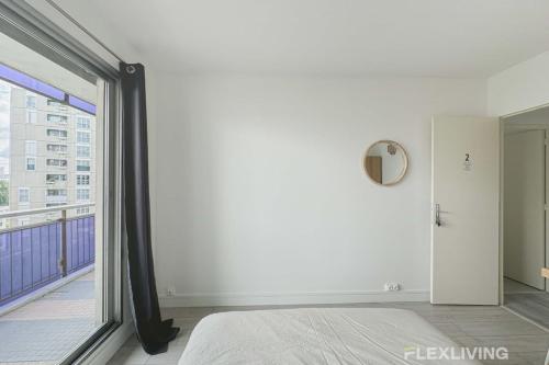 une chambre avec un lit et une grande fenêtre dans l'établissement Flexliving - room - Mouchez, à Paris