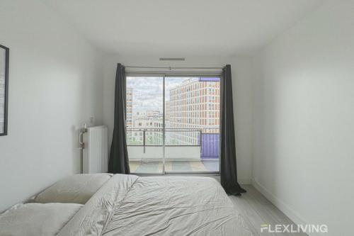 une chambre avec un lit et une grande fenêtre dans l'établissement Flexliving - room - Mouchez, à Paris