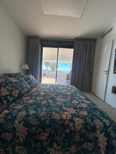 une chambre avec un lit avec un couvre-lit fleuri dans l'établissement Le Murano Sea Sete and Art, à Sète