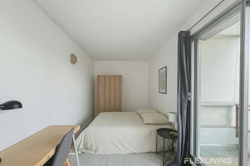 une chambre avec un lit, un bureau et une fenêtre dans l'établissement Flexliving - room - Mouchez, à Paris