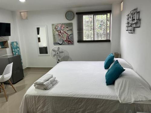 a bedroom with a large bed with blue pillows at Hotel Orduz Centro Histórico de Cali in Cali
