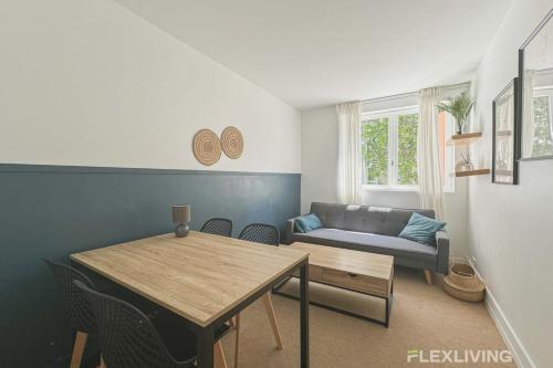un salon avec une table et un canapé dans l'établissement Flexliving - room - Friant, à Paris