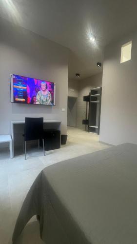 a bedroom with a bed and a television on a wall at La casa di Alice Cocus City in Ravanusa