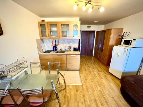 a kitchen with a glass table and a white refrigerator at Julia Vigo Panorama apartments in Nesebar