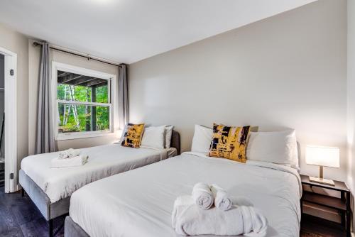 a bedroom with two beds with towels on them at Muskoka Waterfront Retreat in Dwight