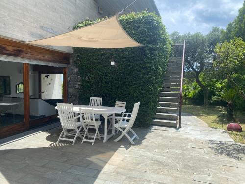 a table and chairs with an umbrella on a patio at Affitti Brevi Liguria - Villa Gioia in Celle Ligure