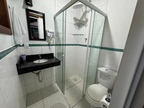 a bathroom with a shower with a toilet and a sink at Casas Temporada Aldeia Niura Opy in Florianópolis