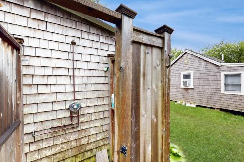 a wooden fence next to a house at Cozy Escape on the Cape in Eastham