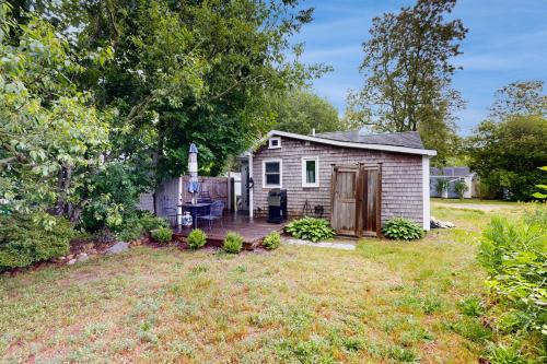 a small house with a deck in a yard at Cozy Escape on the Cape in Eastham