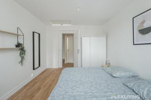 - une chambre blanche avec un lit et une couverture bleue dans l'établissement Flexliving - Room - Henri Sellier - Suresnes 92, à Suresnes