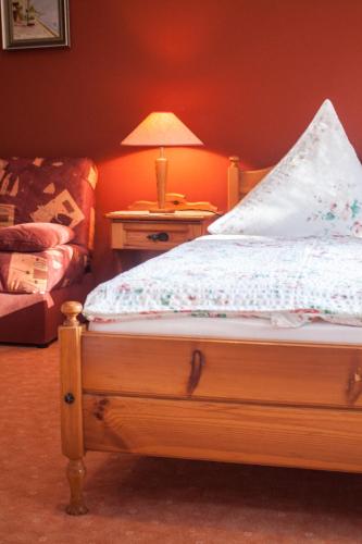 a bedroom with a bed and a table with a lamp at Landgasthof zur Quelle in Seeshaupt