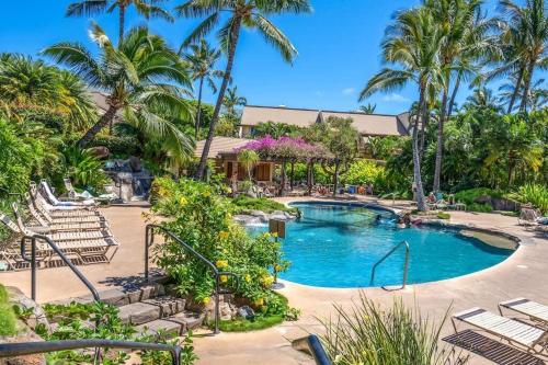 a pool at the resort with chairs and palm trees at Tropical Paradise 1-bed 2-bath Oasis At The Pool in Wailea