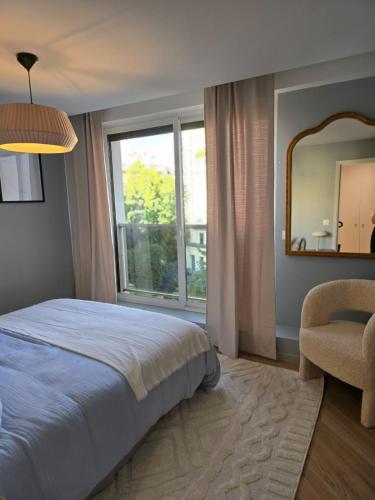 une chambre avec un lit, un miroir et une chaise dans l'établissement Henri martin, vue Tour Eiffel Trocadéro luxe et chic, à Paris