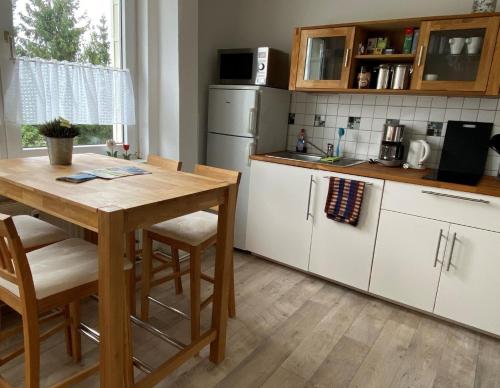 a kitchen with a wooden table with chairs and a counter at Wohnung in Lelkendorf mit Großem Balkon - b48801 in Lelkendorf