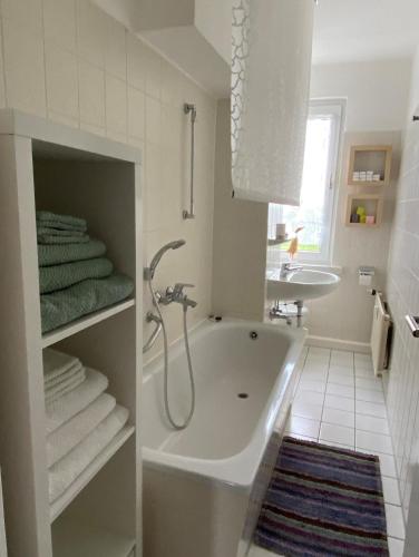 a white bathroom with a tub and a sink at Wohnung in Lelkendorf mit Großem Balkon - b48801 in Lelkendorf
