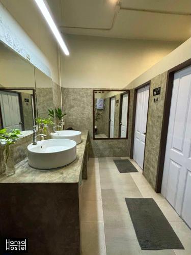a bathroom with two sinks and two mirrors at Hansa Hostel Bangkok Khaosan in Bangkok