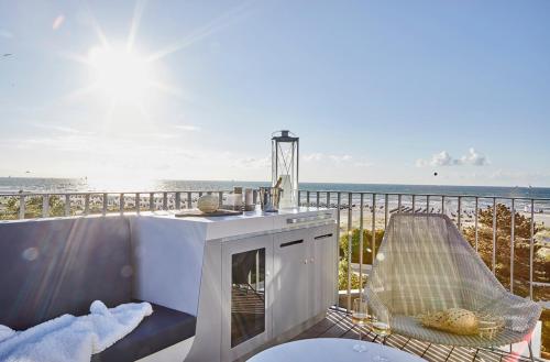 a balcony with a table and chairs and the ocean at Baltic Hideaways Beach Hotel Warnemünde in Warnemünde