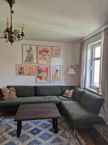 a living room with a green couch and a table at Pæn central lejlighed med gratis parkering in Randers