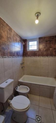 un baño con inodoro y bañera en Los Cohiues Temporario, en Río Grande