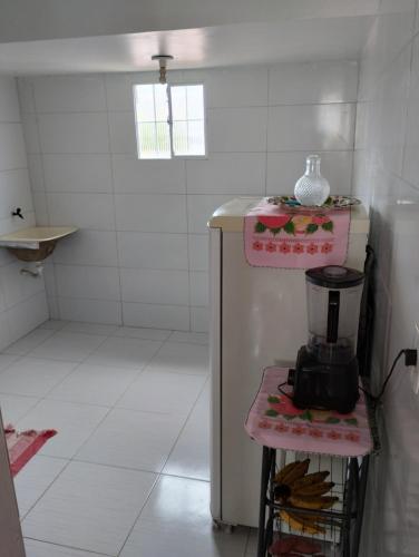 a small white kitchen with a blender on a shelf at Casa in Campina Grande