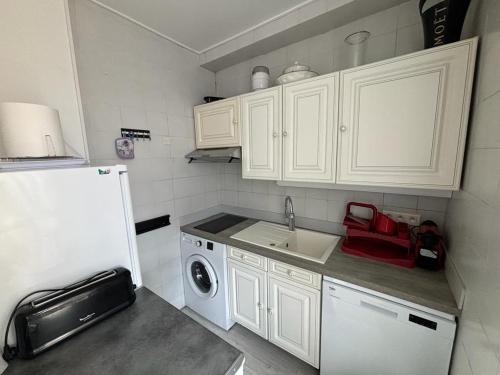 une petite cuisine avec un évier et un réfrigérateur dans l'établissement Studio Cannes Carré d'Or, à Cannes