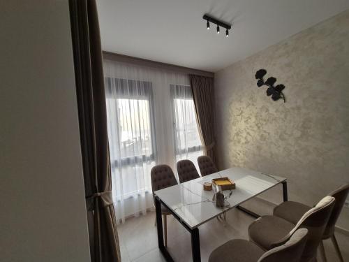 a dining room with a table and chairs and a window at Vienna Luxury Apartments in Dobra Voda