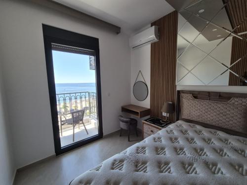 a bedroom with a bed and a view of the ocean at Vienna Luxury Apartments in Dobra Voda