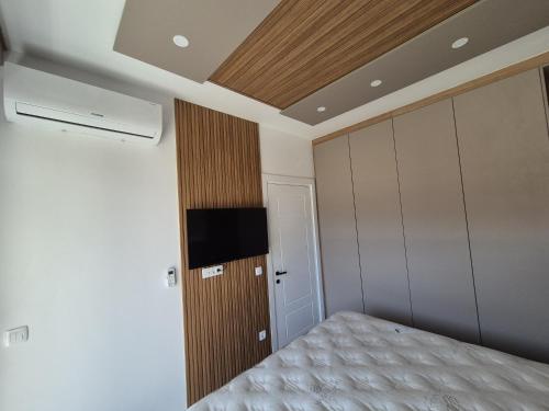 a bedroom with a bed and a tv on the wall at Vienna Luxury Apartments in Dobra Voda