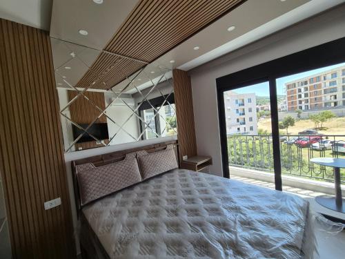 a bedroom with a bed and a large window at Vienna Luxury Apartments in Dobra Voda