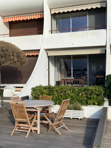 un patio avec une table et des chaises devant un bâtiment dans l'établissement marina avec son bateau, au Grau-du-Roi