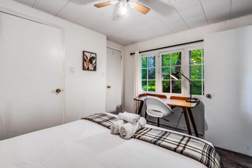a bedroom with a bed and a desk and a window at Muskoka Waterfront Retreat in Dwight