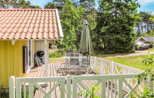 eine Terrasse mit Sonnenschirm und Tisch und Stühlen in der Unterkunft 3 Bedroom Cozy Home In Nexø in Neksø