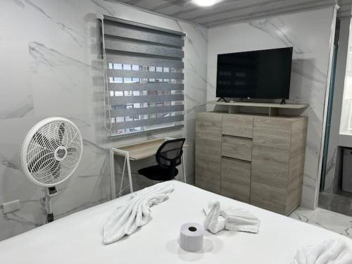 a room with a fan a desk and a tv at Hotel Orduz Centro Histórico de Cali in Cali