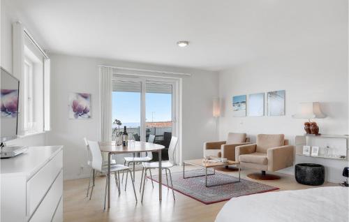 a white living room with a table and chairs at Casa Blanca in Gudhjem