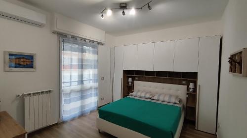 een slaapkamer met een groen bed en een raam bij Conca del Sole in Rapallo