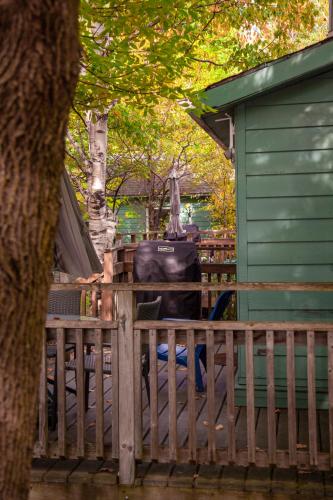 a green house with a wooden fence and a tree at Muskoka Waterfront Retreat in Dwight