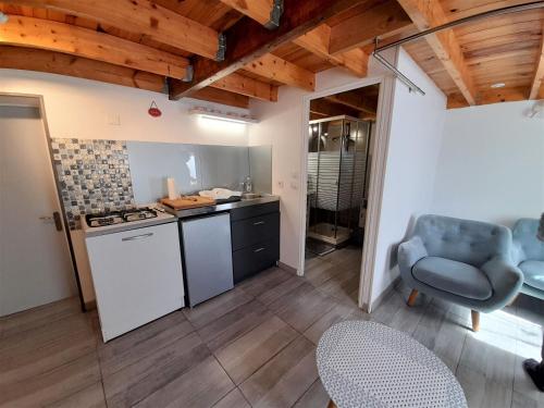 - une cuisine avec une cuisinière et une chaise dans la chambre dans l'établissement Ty Daou gwez, à Irodouër