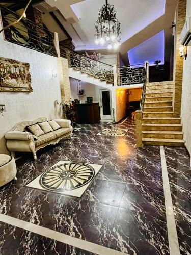 a living room with a couch and a staircase at Lux Palace Hotel in Kutaisi