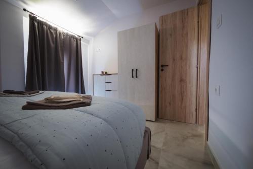 a white bedroom with a bed and a window at Armonia House in Dhíkella