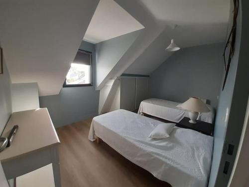 une petite chambre avec deux lits et une fenêtre dans l'établissement Charmante maison golfe du Morbihan, à Saint-Armel