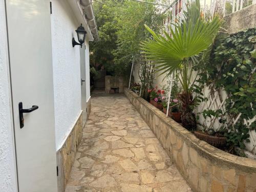 a stone walkway leading to a house with plants at Villa GAN EDEN in La Drova