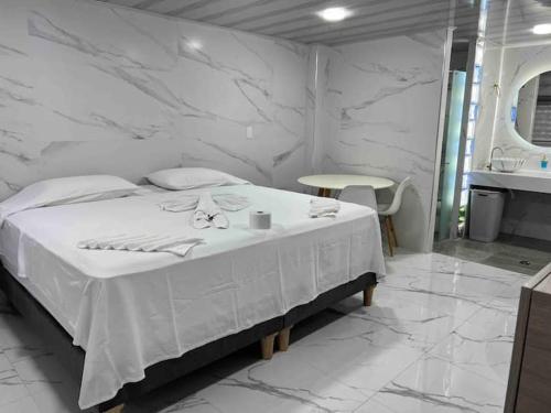 a white bedroom with a bed and a sink at Hotel Orduz Centro Histórico de Cali in Cali