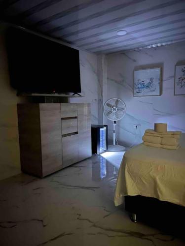 a living room with a flat screen tv and a table at Hotel Orduz Centro Histórico de Cali in Cali