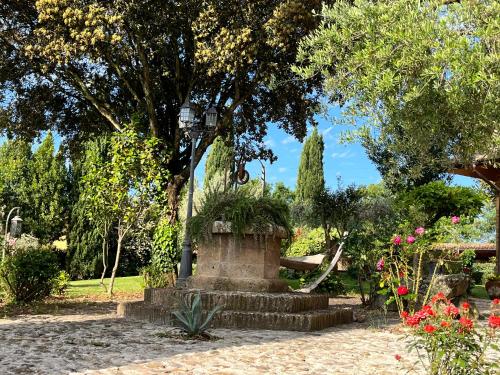 a park with a fountain and trees and flowers at I Fontanili in Civita Castellana