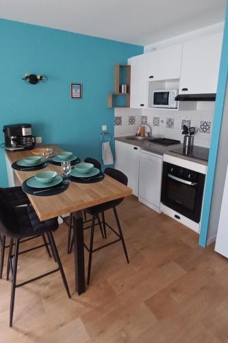 une cuisine avec une table et des chaises dans une pièce dans l'établissement Entre Golf et Mer, à Pornic