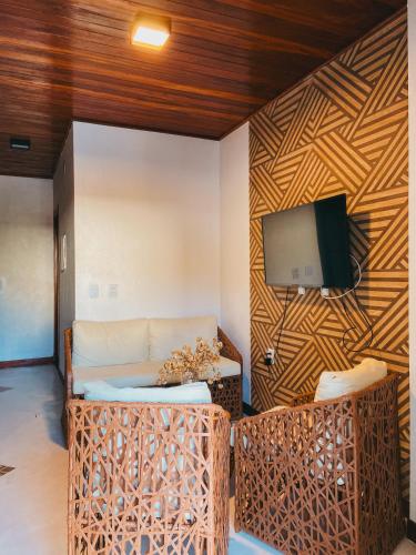 a living room with a couch and a tv on a wall at Velho Chico in Icaraí