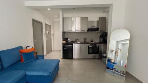 un salon avec un canapé bleu et une cuisine dans l'établissement Appartement près de la gare St Charles, à Marseille