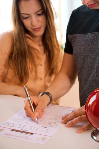 a woman signing a piece of paper with a pen at Le Bignele in Marano di Valpolicella